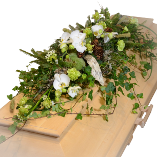 Blommor och gröna blad dekorerar ett ljust träkistlock, vilket skapar en naturlig och fridfull atmosfär.